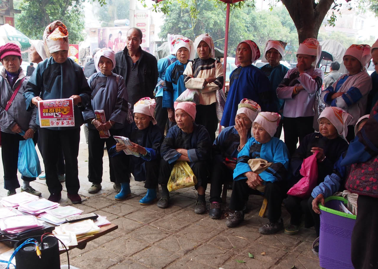 rassemblement de Zhuang au marché devant un écran de tv